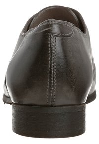 Donkergrijze leren schoen met een gladde textuur, afgeronde vorm en een lage zwarte hak. Heeft nette stiksels langs de achterkant.