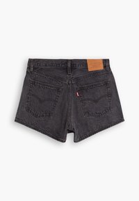 Pantalones cortos de mezclilla negra con cintura alta, dos bolsillos traseros y una etiqueta de cuero marrón con detalles de la marca. La textura parece ligeramente desgastada.