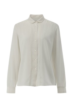 Blusa bianca a maniche lunghe con bottoni sul davanti, colletto piccolo a punta e sottili pieghe verticali ai lati dei bottoni.