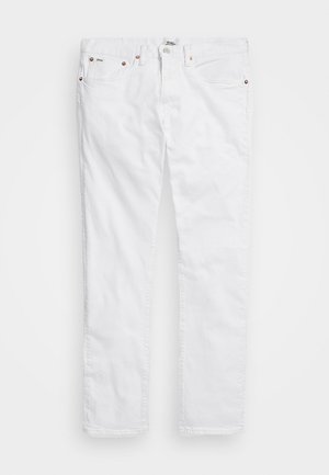 Hvide slim-fit jeans med fem lommer og kobbernitter, lagt fladt på en lys baggrund.
