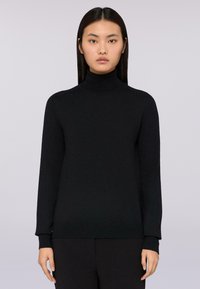 Svart polotröja med lång ärm, lätt stickad tyg, ribbade cuffar och fåll, åtsittande passform, enkel design utan mönster.