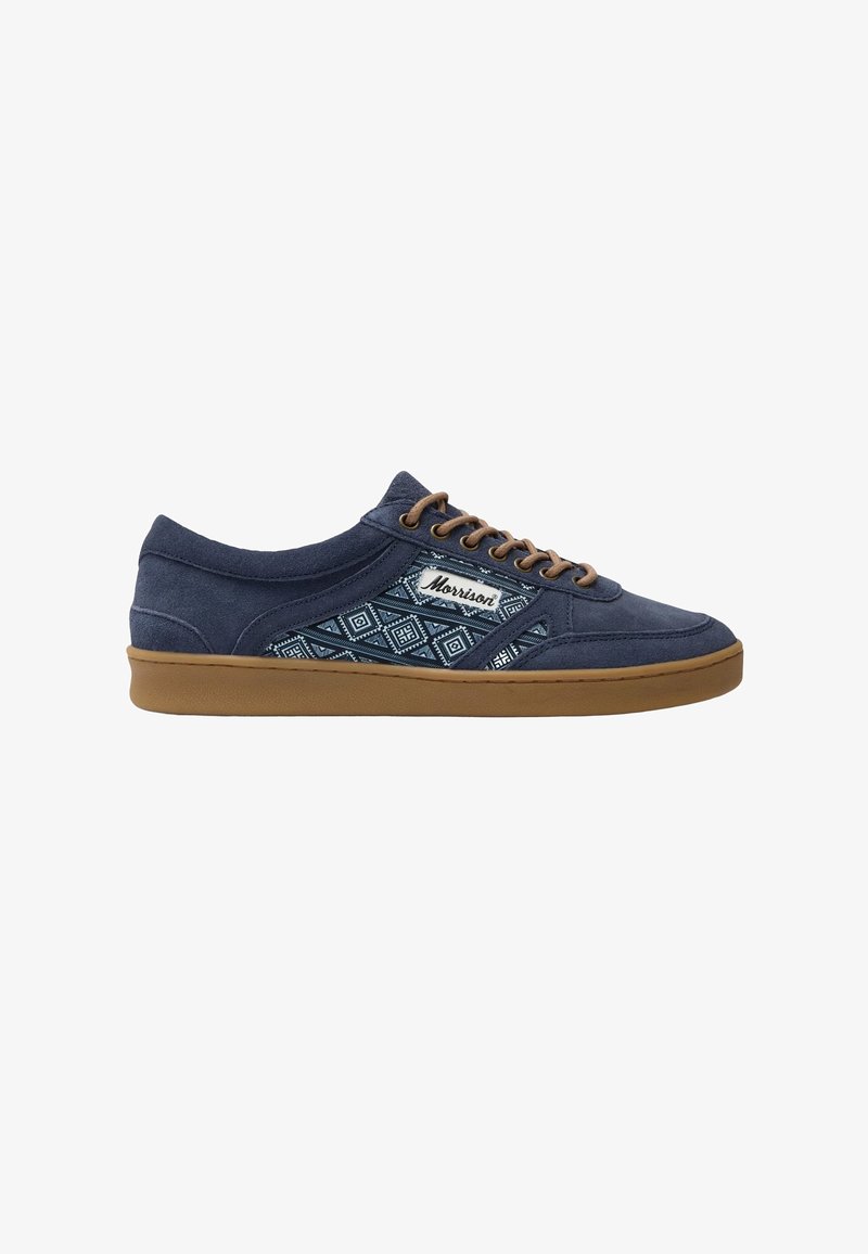 Baskets décontractées bleu foncé avec semelle et lacets marron, avec un panneau en tissu à motifs et une étiquette "Morrison" sur le côté.