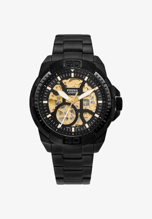 Schwarze Metall Fossil Automatikarmbanduhr mit sichtbarem goldfarbenem Zahnradmechanismus, kräftigen weißen Stunden- und Minutenzeigern und schwarzem Gliederarmband.