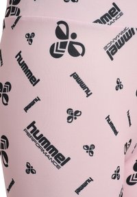 Roze leggings met een herhalend zwart logo-ontwerp. Gemaakt van een gladde, rekbare stof, die comfort en flexibiliteit benadrukt.