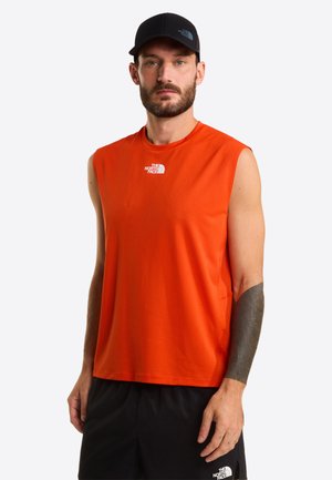 Pomarańczowa sportowa koszulka bez rękawów z okrągłym dekoltem i małym białym logo na piersi, w zestawie z czarnymi szortami. Gładka faktura tkaniny.