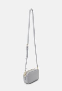 Borsa a tracolla grigia con texture, zip dorate, cinturino regolabile e forma rettangolare. Finitura liscia con design minimalista.
