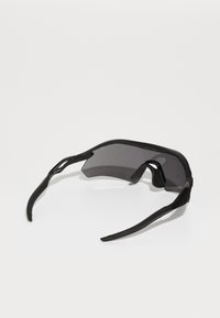 Black sunglasses with a wraparound design, featuring dark gray lenses and slender, flexible arms. Includes a textured nose pad for comfort.