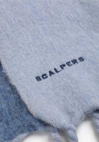 Écharpe en laine bleue à la texture douce, présentant une teinte plus claire et le mot brodé "SCALPERS" en contraste avec un bleu marine.