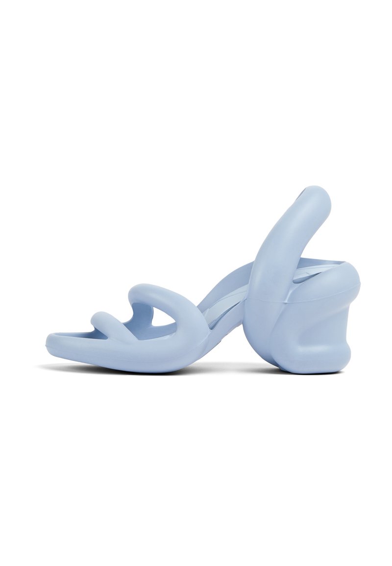 Light blue heeled sandals, made of smooth rubber, featuring a sculptural design with wavy straps and a chunky heel.