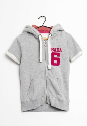 Gray short-sleeve zip-up hoodie with white drawstrings, front pockets, pink lining, and red "Osaka 6" text on the chest hanging on a black hanger.