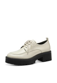 Beige patenten lederen schoenen met een ronde neus, vetersluiting en een dikke zwarte plateauzool met een gestructureerd oppervlak.