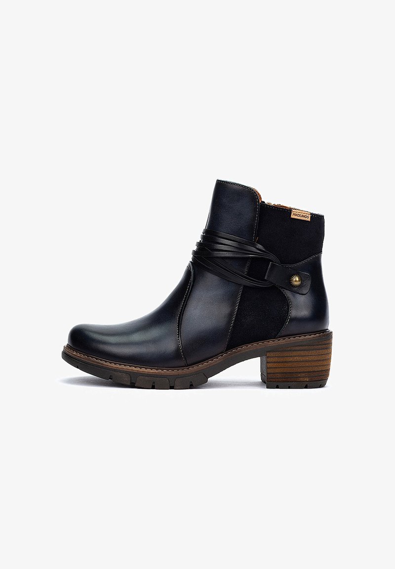 Bottines en cuir noir avec des accents en suède, détail de sangle en cuir enroulée, bout rond et un talon en bois texturé.