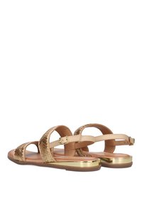 Sandalias beige con patrón tejido y acentos metálicos dorados. Presentan un diseño de punta abierta y hebillas ajustables para un ajuste seguro.