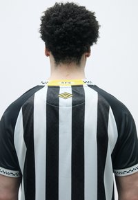 Svart og hvit stripete jersey, korte ermer, rund krage med gule detaljer, med logo og "SFC"-merke på baksiden av halsen.