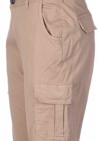 béžové cargo kalhoty s hladkou texturou, vybavené boční kapsou a zapínáním na knoflík. Navrženy pro užitečnost s volným střihem a praktickým úložným prostorem.