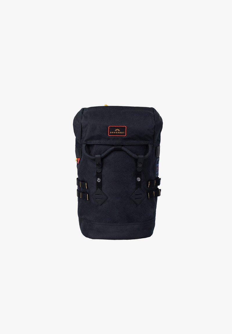 Sac à dos en toile noire avec fermeture enroulable, bretelles réglables, accents jaunes et patch logo sur le devant. Comprend des poches latérales et des détails en métal.