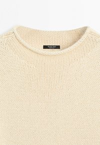 Pull en maille épaisse couleur crème avec un col rond et une étiquette noire Massimo Dutti cousue à l'intérieur du col.