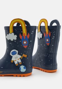 Jūras spēku gumijas lietus zābaki ar astronauta un raķešu dizainiem. Iekļauti varavīksnes rokturi un spilgti oranša zole, lai piešķirtu papildu kontrastu.