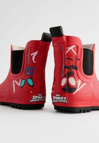 Rote Gummistiefel für den Knöchel mit schwarzen elastischen Seitenpaneelen, die Spider-Man-Designs und Logos aufweisen, strukturierten Sohlen für besseren Grip und einer glatten Oberfläche.