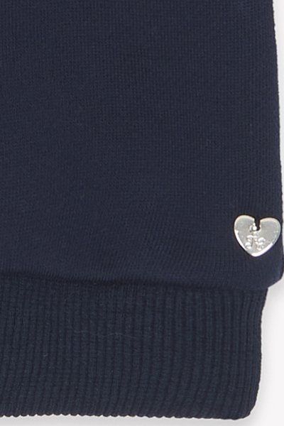 Pullover lavorato a maglia blu navy con polsini a coste, con un piccolo logo a forma di cuore argentato sul lato. Tessuto strutturato.