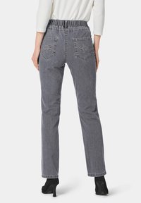 Grijze denimjeans met een geplooid elastische tailleband, rechte pijpen en twee achterzakken met decoratieve stikdetails.