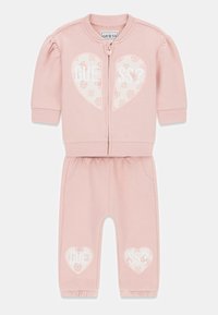 Roze cropped jack met rits, pofmouwen en hartvormige logo's; bijpassende joggers met elastische boorden en zijzakken. Zacht katoenen materiaal.