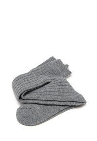 Vouwen paar ribbelige grijze wollen sokken op een witte achtergrond.