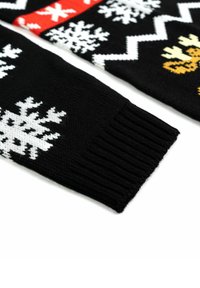 Schwarze Strickpullovern mit weißen Schneeflockenmuster, einem roten Band und gelben Rentiermotiven an den Ärmeln. Die gerippte Struktur des Bündchens ist sichtbar.
