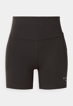 Pantalones cortos deportivos de talle alto en color negro, fabricados en un material elástico, con bolsillos laterales y un sutil logotipo blanco en la parte inferior de la pierna.