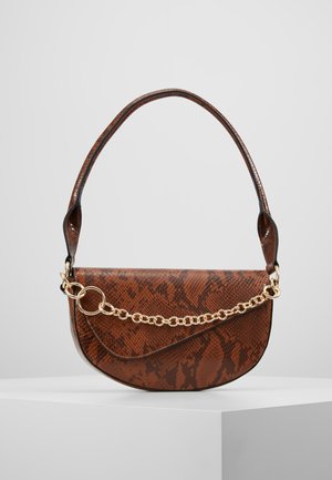 Bruine schoudertas met slangenhuidpatroon, gekromde klep en gouden kettinkdetail, liggend op een witte ondergrond tegen een grijze achtergrond.