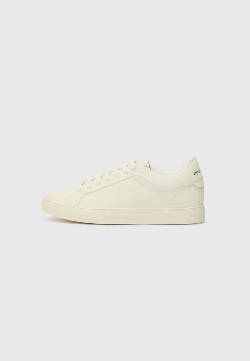 Hvite lærersneakers med minimalistisk design, strukturert overdel og rund tå. Har gummisåle og diskret merkevare på hælen.