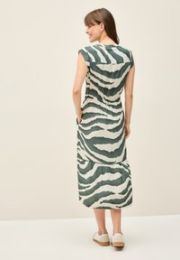 Maxi-mekko, jossa on vihreä-valkoinen seeprakuvio, rento leikkaus, lyhyet hihat ja taskut. Pehmeä kangas, jossa on kerrokselliset helmapitsit.