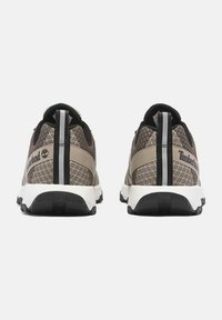 Bruine en beige Timberland sneakers met een bovenwerk van mesh, contrasterende donkere accenten en een witte zool. Kenmerkt zich door een verticale zwarte streep op de hiel.