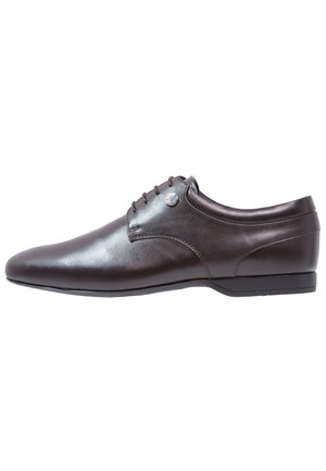 Chaussure habillée pour homme en cuir marron foncé avec fermeture à lacets et talon bas, vue de profil extérieur sur fond blanc.