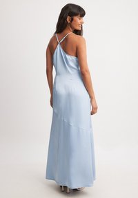 Šviesiai mėlynas satino maksi suknelė su plonomis petnešėlėmis, rendah nugarą ir diagonaliu siūlės detalė, pasižyminti lygia ir sklandžia tekstūra.