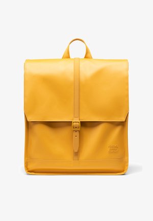 Mochila de cuero amarillo con cierre de solapa, correa frontal ajustable y logo en relieve en el lateral, con una textura elegante y suave.