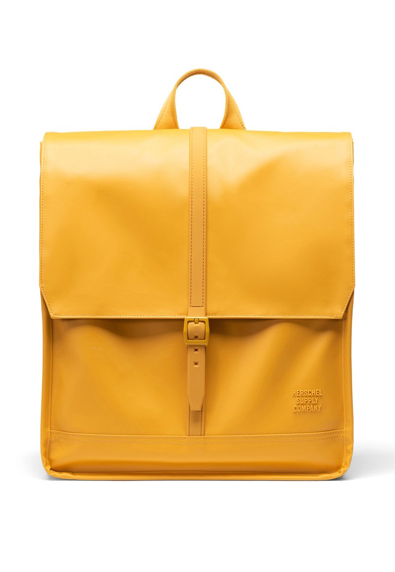 Sac à dos en cuir jaune avec fermeture à rabat, sangle frontale réglable et logo embossé sur le côté, présentant une texture lisse et élégante.
