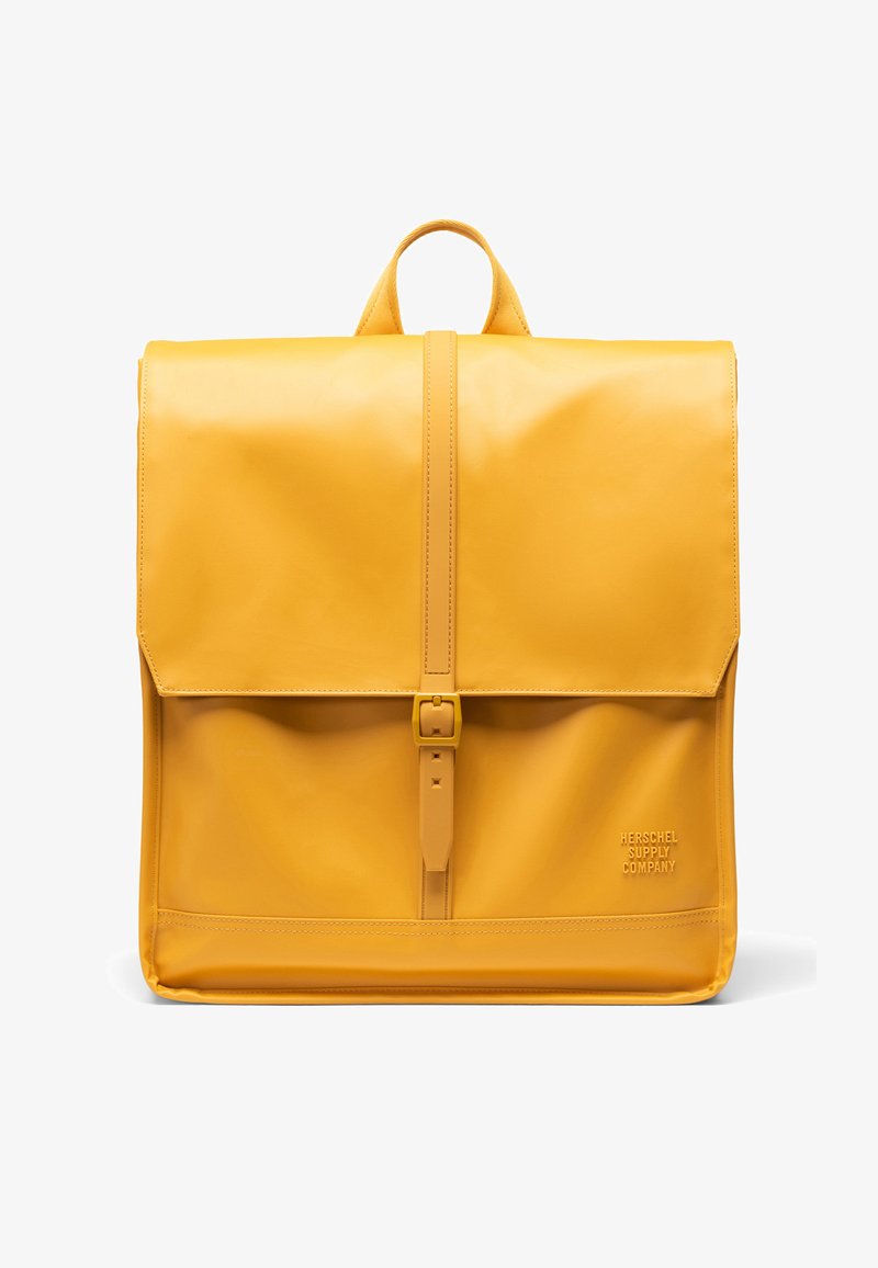 Sac à dos en cuir jaune avec fermeture à rabat, sangle frontale réglable et logo embossé sur le côté, présentant une texture lisse et élégante.