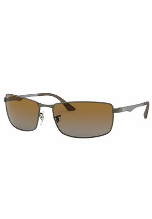 Occhiali da sole con lenti rettangolari a sfumatura marrone, montatura in metallo sottile, dettagli in argento e punte delle tempie in gomma marrone.