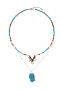 Collier perlé présentant des perles turquoise, rouges et blanches, avec un design en couches. Comprend un pendentif central complexe et un charme en forme de main turquoise.