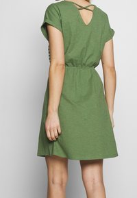 Grünes kurzärmliges Kleid mit geraffter Taille, V-förmigem Rücken und gekreuzten Trägern. Weicher, strukturierten Stoff mit einer lässigen, fließenden Silhouette.