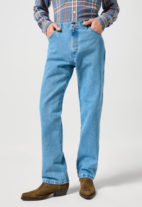 Lichtblauwe spijkerbroek met een recht model, vijf zakken en een hoge taille. Voorzien van een stevige knoop en ritssluiting.