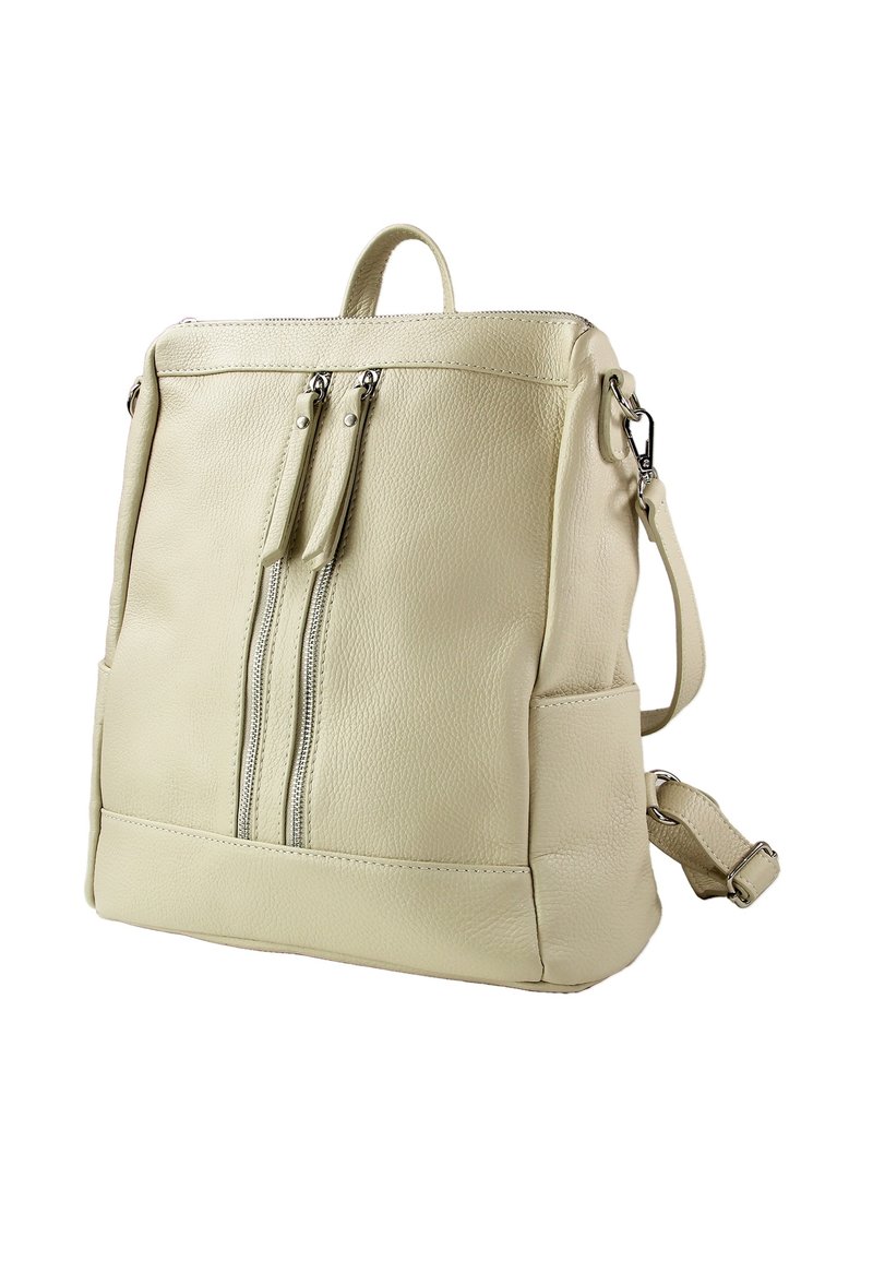 Sac à dos en cuir beige clair avec deux zips à l'avant, une bandoulière réglable, une poignée supérieure et une poche latérale. Texture lisse et design minimaliste.