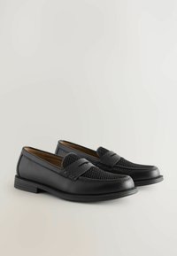 Zwarte loafers met een glad leren lichaam en een gestructureerde geweven accent op het teengebied. Rond de teen en met een vlakke rubberen zool voor stabiliteit.