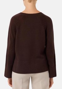 Maglione marrone a maglia con un design a coste testurizzato, maniche raglan e orlo dritto. Il tessuto sembra morbido e resistente.