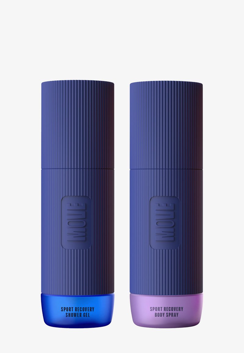 Två cylindriska lila flaskor med ribbad textur. Den vänstra har en blå bas som är märkt "Sport Recovery Duschgel", och den högra har en rosa bas som är märkt "Sport Recovery Kroppsspray."