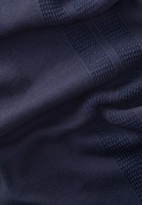 Marineblå tekstureret stof med glat strik og ribbede mønstre, der har skiftende striber i forskellig vævning. Højkvalitets tekstildesign.