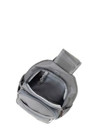 Sac à dos gris en tissu résistant, doté de plusieurs compartiments zippés et d'une poignée rembourrée sur le dessus pour un transport facile.