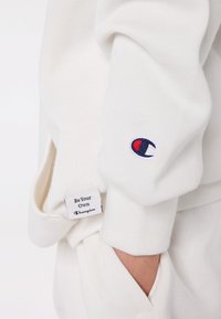 Champion EXCLUSIVE HOODIE UNISEX - Sportinis megztinis - off-white