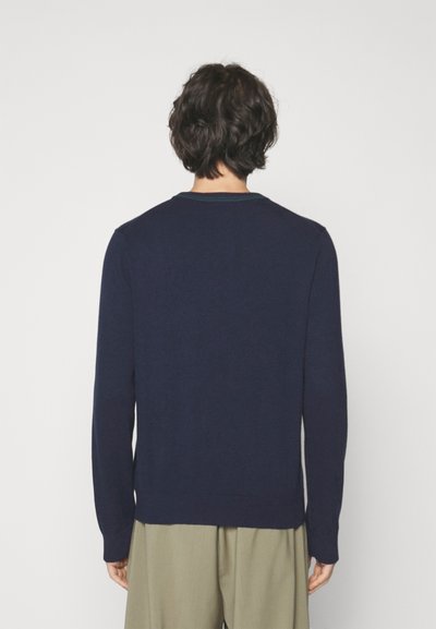 Pull en maille bleu marine à manches longues, col rond côtelé et ceinture. Texture douce, design simple, minimalisme dans les détails.